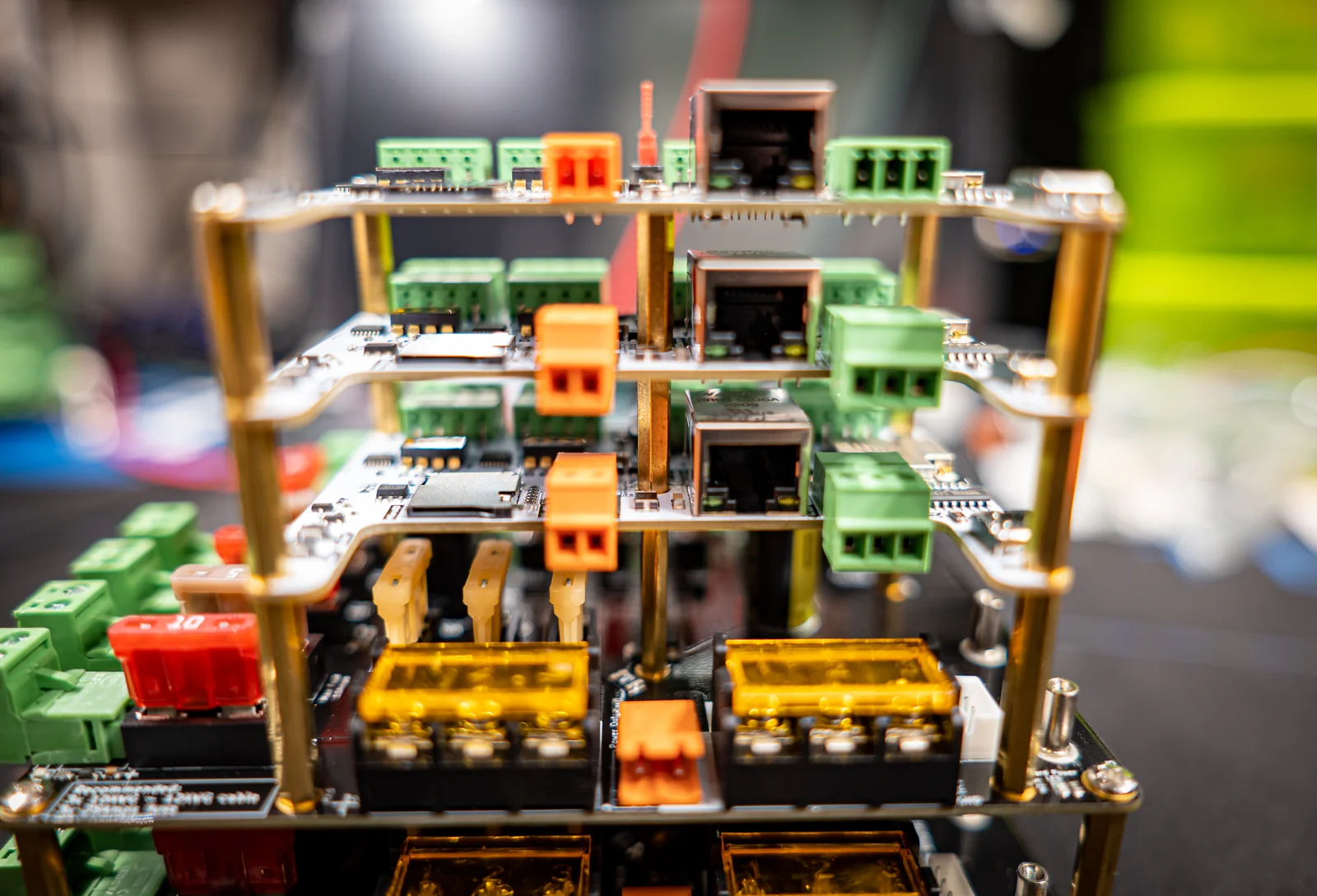 Tall Dig-Octa demo stack: three white brainboards with Ethernet jacks on brass QPowerPost standoffs above a black powerboard with amber fuse covers
